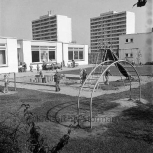 Außenanlage des Evangelischen Kindergartens "Ehmkenberg" im evangelischen Gemeindezentrum "Haus der Begegnung", rechts Anbau mit Wohnungen: im Hintergrund Wohnhochhäuser der Straße Im Hölk: Blick von Südosten