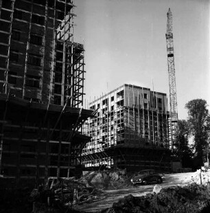 Sülzberg: zwei Wohnblocks mit Gerüsten im Bau: vorn Erdhaufen, Baumaterial, Baumaschinen und VW-Käfer: hinten rechts Baukran und Bäume