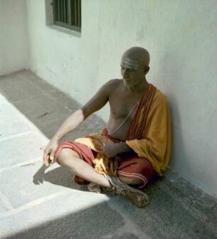 Sitzender Mann, an eine Hauswand gelehnt, bei Meditation : Varanasi (Indien). Sitzender Mann, an eine Hauswand gelehnt, bei Meditation