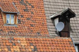 Quedlinburg - Ziegeldächer mit Satellitenschüssel : Historische Ziegeldächer mit einer Satellitenschüssel in der Gasse Hölle. Aufgenommen am 15. Juli 2012 in Quedlinburg