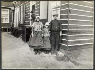 Niederlande, Marken. Kinder in Tracht und Uniform vor einem Wohnhaus
