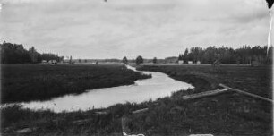 Flusslandschaft : Blick über eine Flusslandschaft mit Holzhütten.