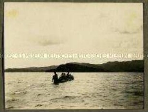 Afrikaner mit Paddeln in einem Einbaumboot beim Ablegen vom Ufer