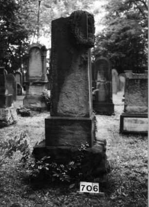 Grabstein 706 (Index: 99630208) Material: Sandstein Zustand: völlig verwittert Maße HxBxT: 170x48x37 cm Beschreibung: Stele auf Doppelsockel, unterer Sockel rustica Symbolik: Kranz um rechte Stelenseite oben, fünfzackiger Stern: Grabstein 706