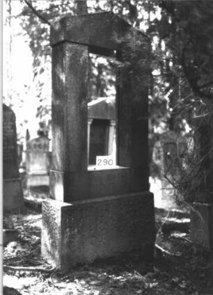 Grabstein 290 (Index: 99898529) Material: Kunststein? Zustand: Schrifttafel verloren, sonst gut erhalten Maße HxBxT: 206x97x30 cm Beschreibung: aufgesockelte Stele mit Giebelaufsatz, Schrifttafel verloren: Grabstein 290