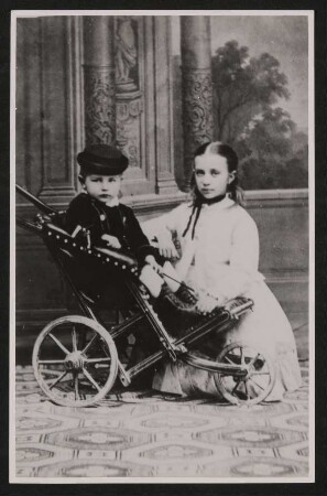 Rudolf Kassner als Kleinkind in einem Kinderrollstuhl mit seiner Schwester