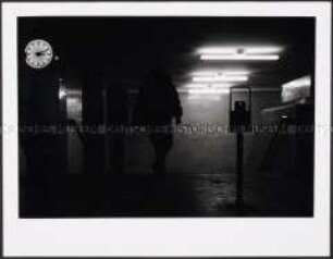 Menschensilhouette nachts in einer U-Bahnstation (Altersgruppe 18-21)