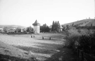 Humor: Kloster, Außenansicht mit Turm, von der Wiese