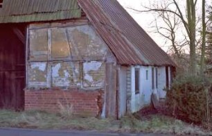 Sehmsdorf: Hofkamp 1: traufständige Fachwerkkate mit Blechdach: Giebelseite Wirtschaftstrakt mit Scheunentor, Teilansicht: Schäden: rückwärtige Traufseite mit Sprung zu Wohntrakt