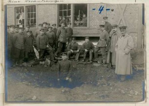 Foto von Soldaten und einem Bombentrichter vor der Reparaturwerkstätte