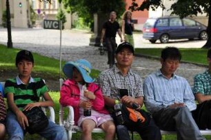 Schlafende chinesische Touristen : Übermüdete chinesische Touristen sitzen auf einer Bank im Strahov-Kloster und sind bei den Erklärungen ihres Reiseführers eingeschlafen. Aufgenommen in Prag am 31. Juli 2009