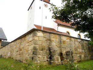 (Sankt Jakobus der Ältere)-Ansicht von Nordosten mit Kirchturm über Kirchhofmauer (Wehrgang mit Steinbrüstung im 19 Jh abgetragen) - Werksteine im Mauersteinverband (erhaltene Zangenlöcher)