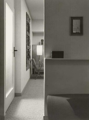 Musterwohnung (1972; Deutsche Bauakademie). Blick in ein Musterwohnzimmer. Wandteppich, Armlehnstuhl und Stehlampe