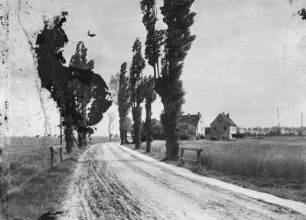 Unbefestigte Landstraße. Blick auf ein Dorf