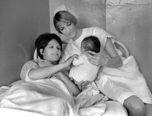 Hebamme mit Mutter und Kind