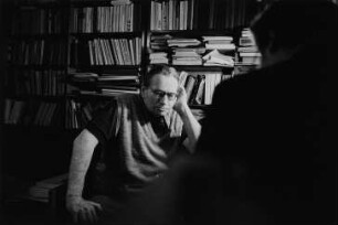 Der Fotograf Milos Korecek vor einem Bücherregal
