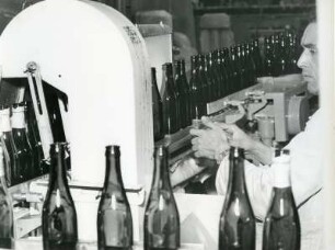 In einer Brauerei. Flaschen werden maschinell gespült. Kontrolle der Flaschen