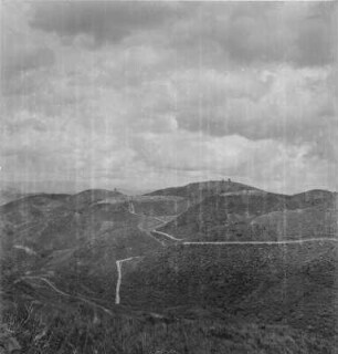 Hügellandschaft : Straße durch eine Hügellandschaft, auf einer Kuppe Lubero