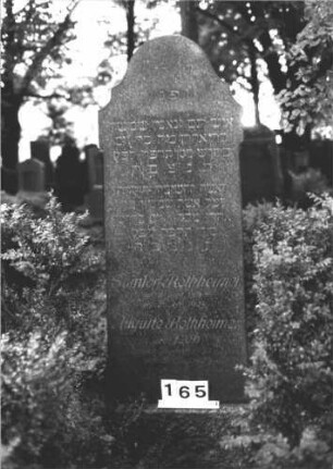 Grabstein 165 (Index: 100082019) Material: Granit Zustand: gut Maße HxBxT: 129x61x26 cm Beschreibung: konische Stele, Sockel, ausgezogener/geschwungen eingezogener Konvexbogenabschluß Steinmetz: Löffler: Grabstein 165