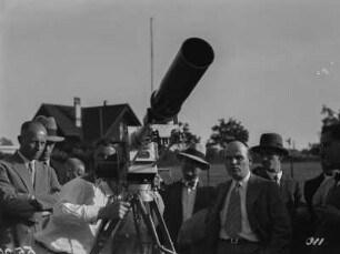 Filmkamera : Ein Mann (vielleicht Schomburgk) prüft die Kamera und Fernbildlinse.