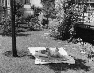 Kinderbilder. Säugling, auf einer Decke in einem Garten liegend