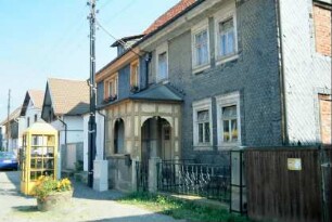 Straße mit Telefonzelle; Haus mit überdachtem Eingangsbereich