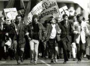 Fünf Demonstranten, Arm in Arm, mit Transparenten