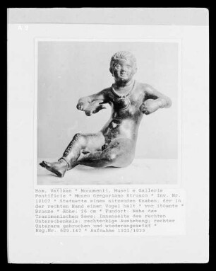Statuette eines sitzenden Knaben, der in der rechten Hand einen Vogel hält