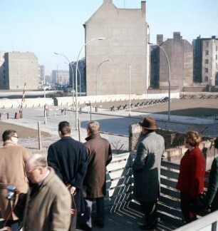 Berlin. Mauerblick ins versperrte Ost-Berlin : Berlin. Westberliner Passanten blicken von einer Tribüne über die Mauer nach Ost-Berlin