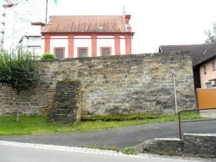 Ansicht im Norden mit Kirche (Langhaus Neubau 1715 auf gotischem Vorgänger) über Kirchhofmauer (Wehrgang mit Steinbrüstung im 18 Jh abgetragen) und Strebepfeiler