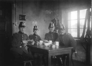 1. Weltkrieg. Vier Soldaten, an einem Tisch sitzend