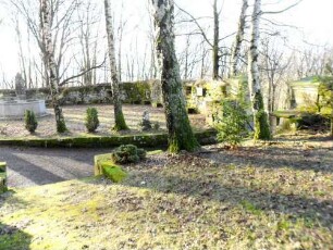 Kirchhof im Westen mit Kirchhofmauer (ehemaliger Wehrgang mit Brüstung abgetragen-Schießscharten in Brusthöhe erhalten) in übersichtlichem Verlauf
