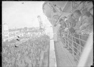Passagiere schauen vom Hochseepassagierdampfer "Bremen" auf Menschenmenge am Kai, "Jungfernfahrt"