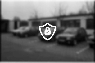 Autohaus [Name maskiert] Gänseberg: Parkplatz mit Pkws: dahinter Werkshalle, hinten links Schuppen: 21. Februar 1990