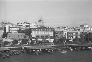 Kaufhaus 'Simon Arzt' in Port Said : Blick auf den Hafen von Port Said mit Booten, der Promenade, dem Kaufhaus 'Simon Arzt' und anderen Gebäuden