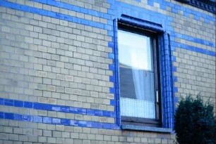 violette, glasierte Klinker als Horizontalbänder in einer Fassade, ebenso in Fenstergewänden