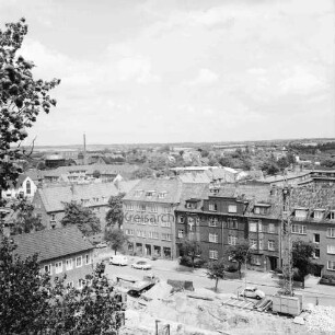 Erweiterungsbau [später Gebäude C] mit Kreistagssitzungssaal: IV. Bauabschnitt: Baubeginn an der Reimer-Hansen-Straße: links Erweiterungsbau II. Bauabschnitt: vorn Baugrube: dahinter parkende Pkws vor Wohnblocks: rechts Baukran: Blick vom "Hochhaus" [später Gebäude B] über Bad Oldesloe Richtung Lübeck