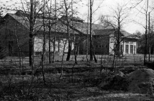Wasserwerk: davor Grünanlage mit Bäumen: vorn rechts Sandhaufen