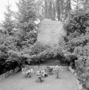 Ehrenmal: vorn Blumenschmuck: hinten Tannen und Bäume