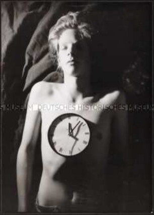 Jugendlicher mit einer auf seinem nackten Oberkörper liegenden Uhr (Sonderthema: Lebenskunst und Lebenskünstler)