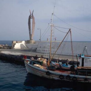 Ikaría. 255km2. Ikaros-Denkmal über der Mole des Landeplatzes Agios Kírykos, Südküste