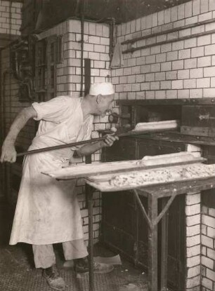 Christstollenbäckerei. Das Einschieben der Stollen in den Backofen