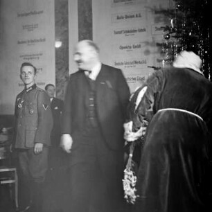 Ein Mann in Wehrmachtsuniform, ein Anderer im Anzug und der Rücken des Weihnachtsmannes, Kinderfest zur Weihnachtszeit