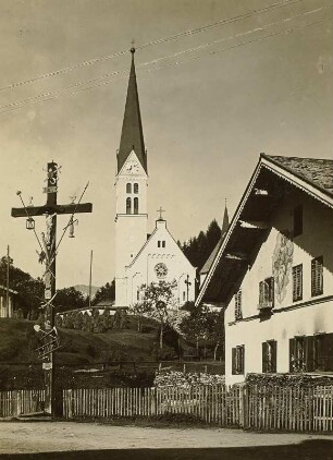 Holzgau im Lechtal. Ortsteilansicht mit Kircheund Kruzifix mit den Marterwerkzeugen
