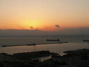 Sonnenuntergang, vorn der Hafen, hinten die spanische Küste