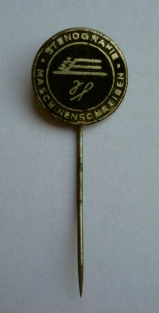 Mitgliedsabzeichen Gesellschaft für Stenografie und Maschinenschreiben der DDR (mit langer Nadel) : Sammlung Beinhorn. Mitgliedsabzeichen Gesellschaft für Stenografie und Maschinenschreiben der DDR (geflügelte Feder und Schreibmaschine sowie Umschrift "Stenografie Maschinenschreiben" auf schwarzem Grund, mit langer Nadel). Email, Metall; Durchmesser 17 mm (1960/1990). Dresden: SLUB R c 0297