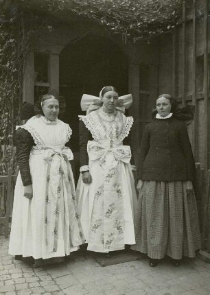 Lausitzer Bergland, Crostwitz. Trachten in der nördlichen Oberlausitz, Gegend zwischen Kamenz-Bautzen-Wittichenau. Frau in Festtracht (links), Mädchen in Festtracht (Mitte), Frau in Alltags- und Sonntagstracht (rechts).