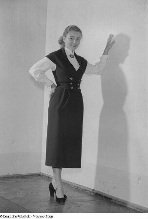 Eine Frau posiert mit Kleid bei der "Internationalen Messemodenschau", Herbstmesse 1953