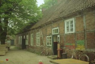 Beekmoorweg 8: ehemaliges Melkerhaus: Mehrfamilienkate mit Fachwerk: Traufseite mit Eingangstüren
