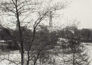 Dresden-Neustadt. Albertplatz von einem Gebäude an der Einmündung Bautzner Straße. Frühlingsaufnahme durch den Baumbestand gegen kathol. Pfarrkirche Franziskus Xaverius und Dreikönigskirche